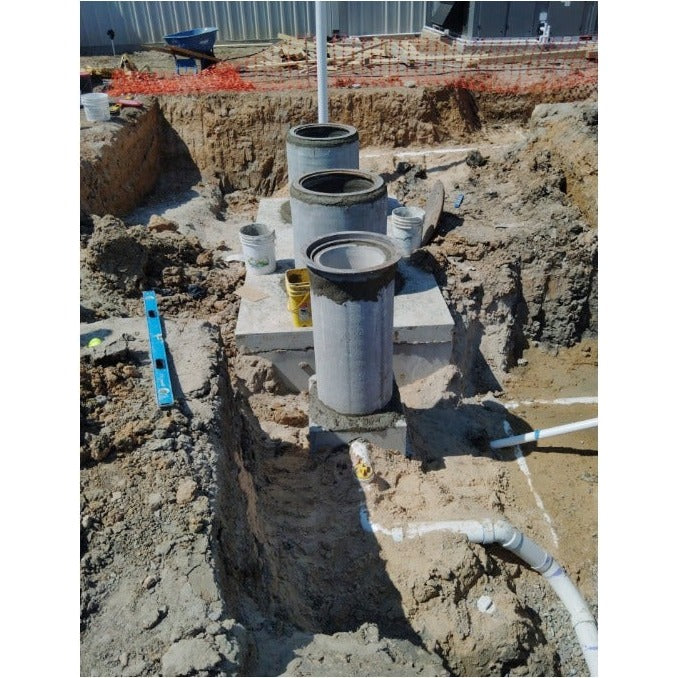 Texas Precast sample well set in an excavation with inlet and outlet piping