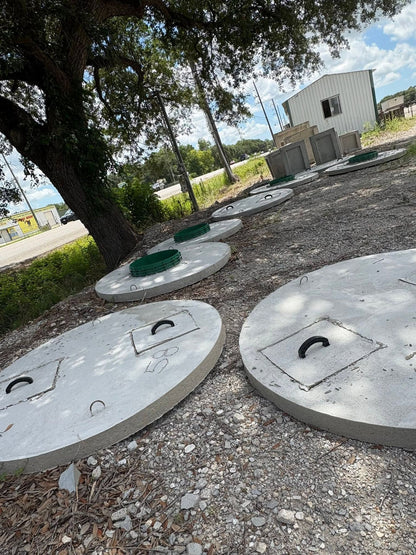 Texas Precast 20 inch septic riser lids stacked in the manufacturing yard