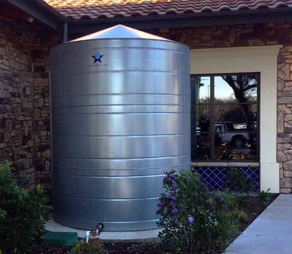 Texas Metal Tanks galvanized steel rainwater tank installed beside a stone building