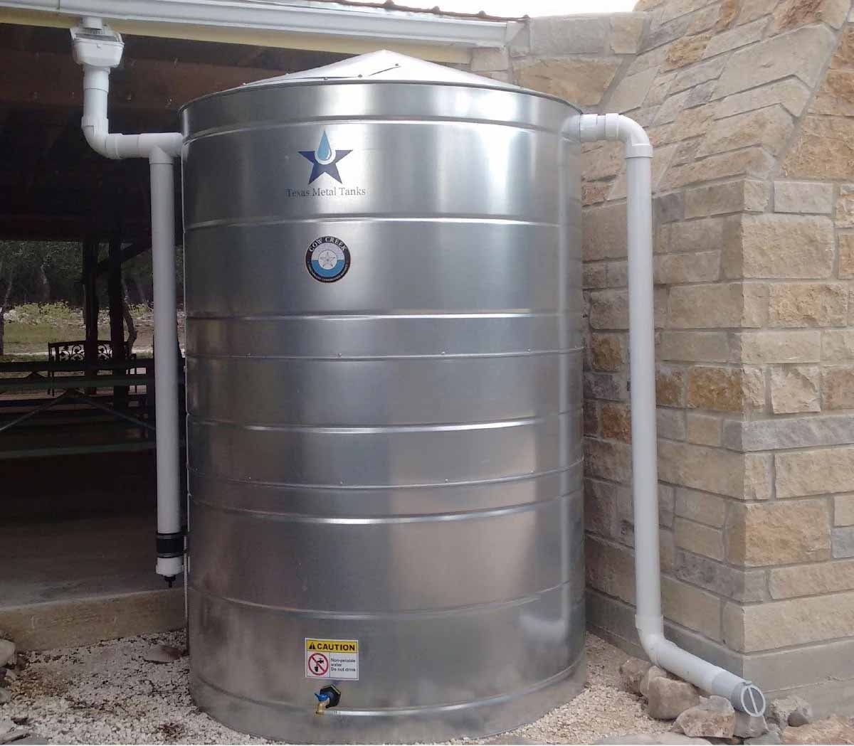 Texas Metal Tanks galvanized steel tank collecting roof runoff through PVC downspouts