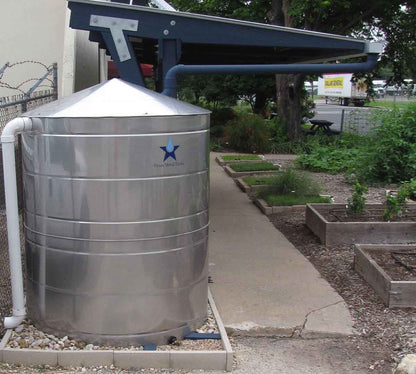 Texas Metal Tanks 830 gallon stainless steel rainwater tank beside a garden path and raised beds
